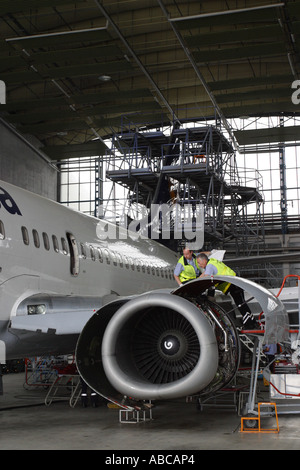 Airliner maintenance engineers work on a Boeing 737 aircraft CFM-56 jet engine in airport hanger Stock Photo