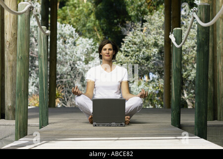 Woman with computer doing yoga Stock Photo