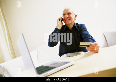 Man using laptop computer and cellphone Stock Photo