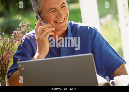 Man using laptop computer and cellphone Stock Photo