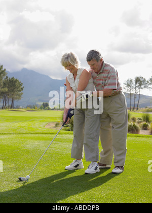 Man giving woman a golf lesson Stock Photo