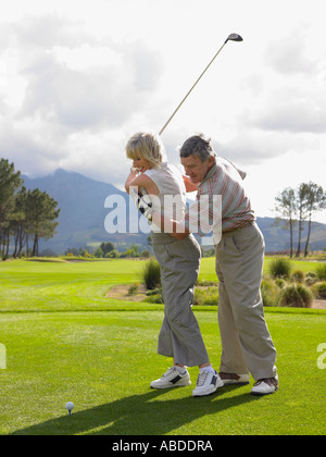 Man giving woman a golf lesson Stock Photo