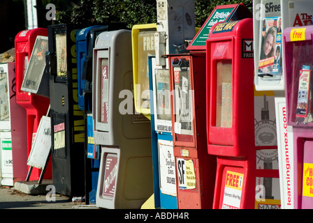 Row of newspaper vending boxes on side of road Stock Photo