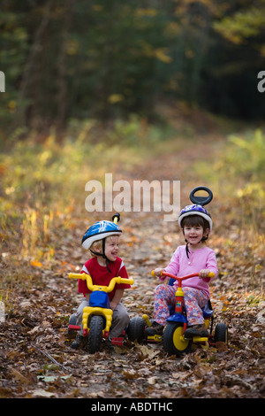 A young boy age 2 and his sister age 4 on their bikes Newfields rail trail in Newfields NH Fall