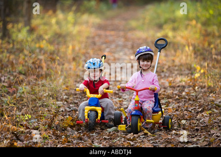 A young boy age 2 and his sister age 4 on their bikes Newfields rail trail in Newfields NH Fall Stock Photo