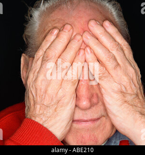 Senior man covering his eyes with his hands Stock Photo