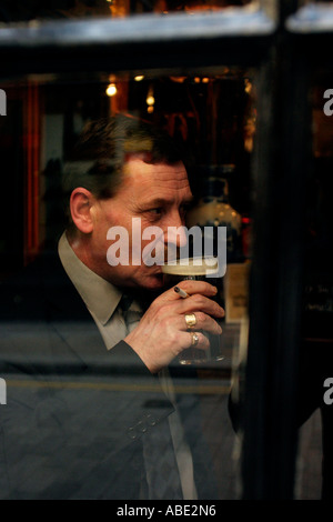 A man drinking a pint of beer in the Old Watling Public House London UK Stock Photo