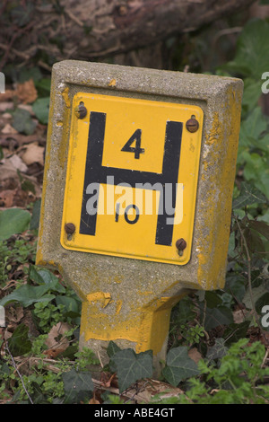 A traditional UK Fire hydrant sign indicating that there is a 4 inch main 10 feet in front of the sign Stock Photo