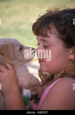 Sweet Young girl 5-7 year old nose-to-nose face to face Golden holding puppy up child playing play plays dog profile side view MR ©Myrleen Pearson Stock Photo