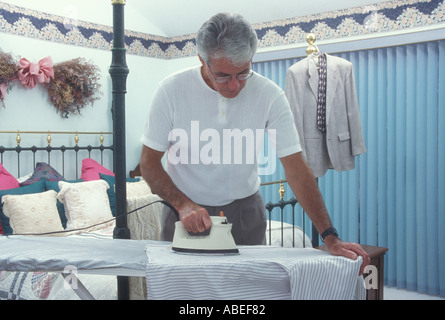 Senior Man ironing a shirt in bedroom self care capable  . POV MR ©Myrleen Pearson Stock Photo