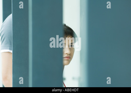 Young woman, seen through blurred foreground Stock Photo