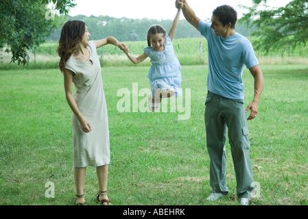 Man and woman holding up daughter in the air Stock Photo