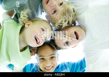Four kids huddling, low angle view Stock Photo