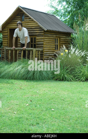 Man standing on porch of log cabin, full length Stock Photo