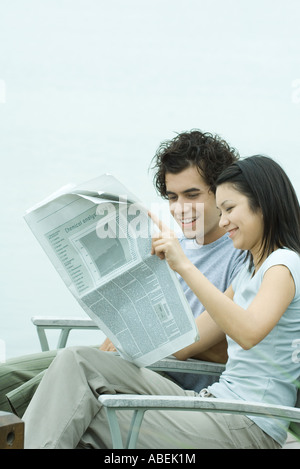 Young couple reading newspaper Stock Photo