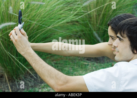 Young couple taking photo of selves with cell phone Stock Photo