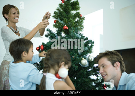 Family decorating Christmas tree Stock Photo