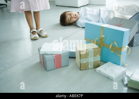 Boy lying on floor next to presents Stock Photo