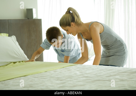Mother and son making bed together Stock Photo