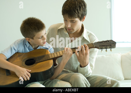 Father and son playing guitar together