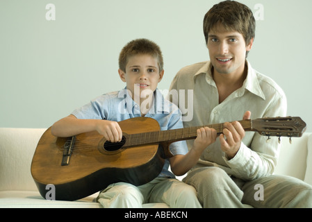 Father and son playing guitar together