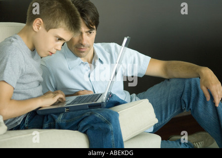 Father and son using laptop together Stock Photo