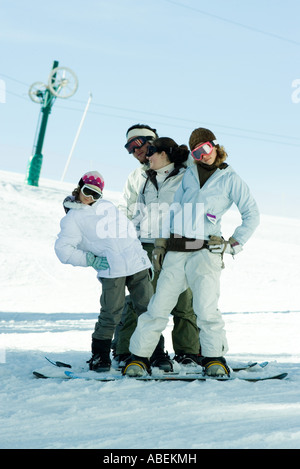 Young snowboarders standing on ski slope, full length portrait Stock Photo