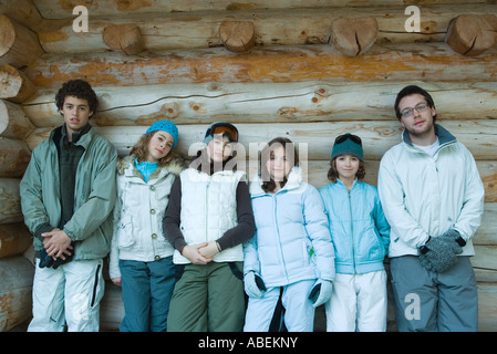 Young friends standing by log cabin, portrait Stock Photo