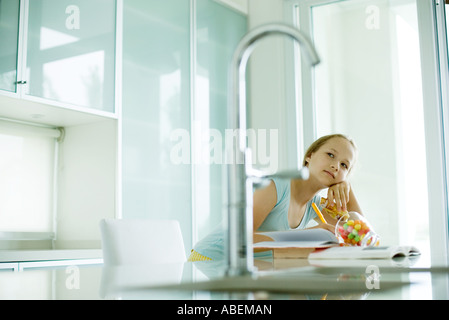 Girl eating sweets and doing homework Stock Photo