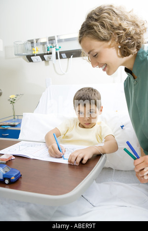 Boy lying in hospital bed, coloring Stock Photo