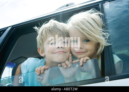 Children sticking heads out of car window Stock Photo