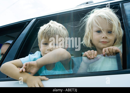 Children sticking heads out of car window Stock Photo