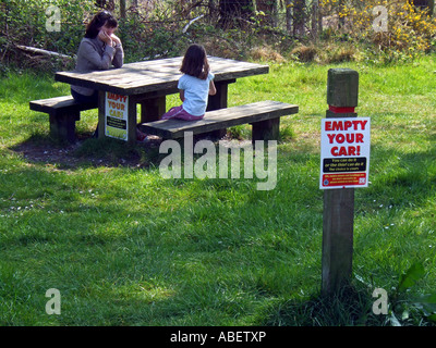 Empty your car warning sign on a post and picnic bench, Dorset Britain, UK Stock Photo