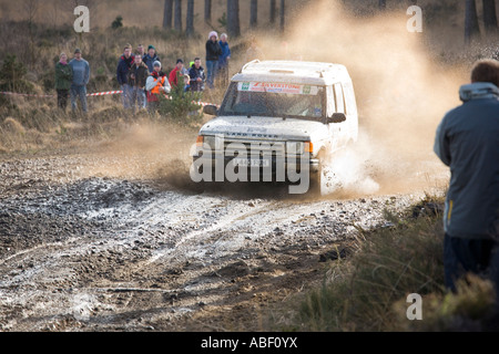 Land Rover Discovery rally car splashes through puddle driving on mud and gravel Stock Photo