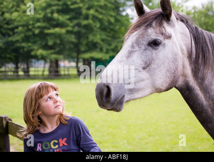 Girl gazing at horse Stock Photo