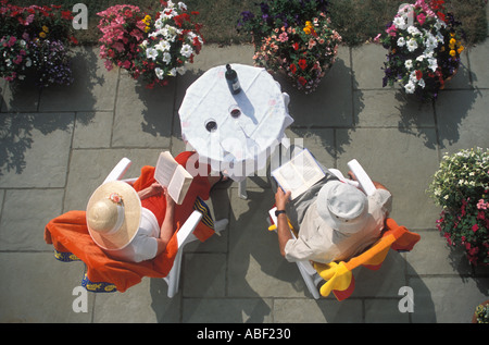 Couple drinking red wine on garden patio Stock Photo