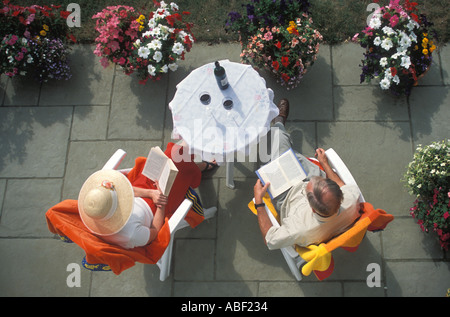Couple drinking red wine on garden patio Stock Photo