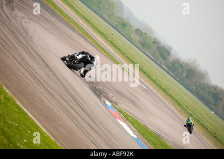 2 racing motorbikes riders lean through bends in superbike competition Stock Photo