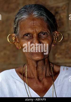 An old Kerala lady with traditional Christian costume and ear rings called mekkamothiram smiling at the Camera Stock Photo