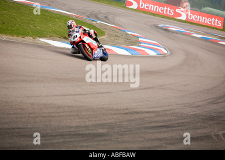 Action - one racing motorbike leans through a corner Stock Photo