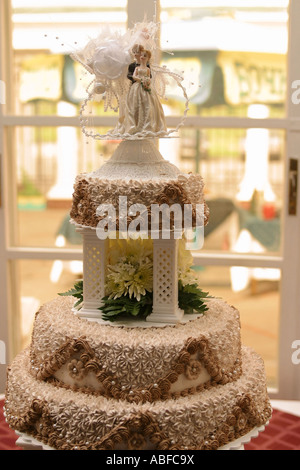 A close up portrait of a traditional tiered wedding cake with a couple on top of it. Stock Photo