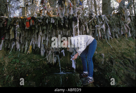 Clootie Well Nr Tore Munlochy Black Isle drinking healing water and hang up a clootie for good luck and good health on May 1st Circa 1995  Scotland Stock Photo