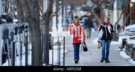 Two young women using cellphones in Lincoln, Nebraska. Stock Photo