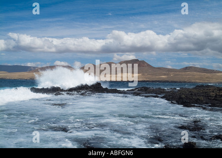 dh  CALETA DE CABALLO LANZAROTE Crashing surf waves breaking on lava rocks in bay Stock Photo