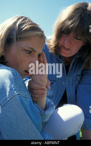 angry mother telling off teenage daughter in outside environment Stock Photo