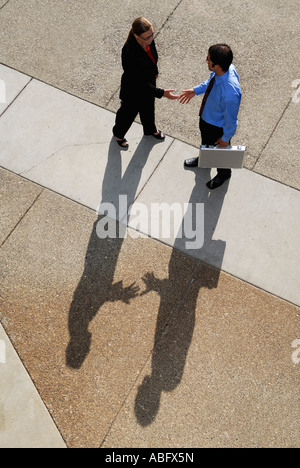 Businessman and woman with shadows meeting with a handshake from above Stock Photo