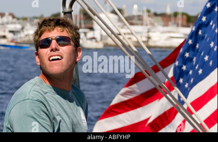 The captain of a sailbot in Rhode Island standing in front of an American Flag. Stock Photo
