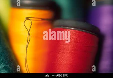NEEDLE AND REELS OF COTTON SEWING THREAD Stock Photo