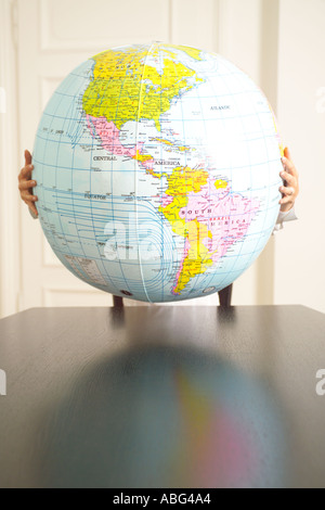 hands holding an inflatable globe Americas prominent Stock Photo