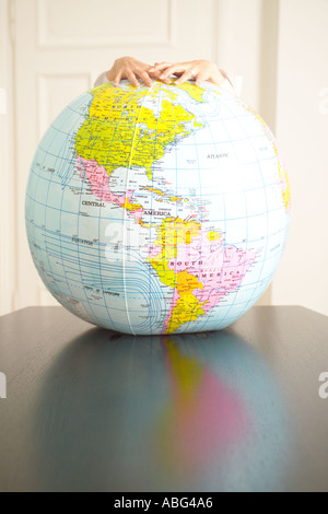 hands holding an inflatable globe Americas prominent Stock Photo